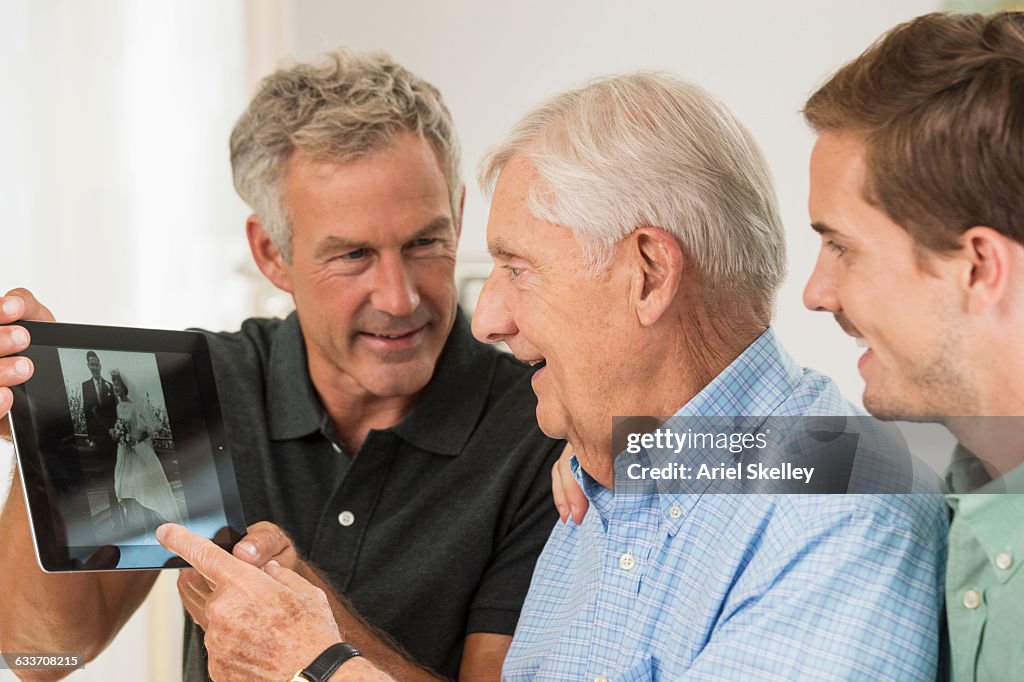 Three generations of Caucasian men using digital tablet