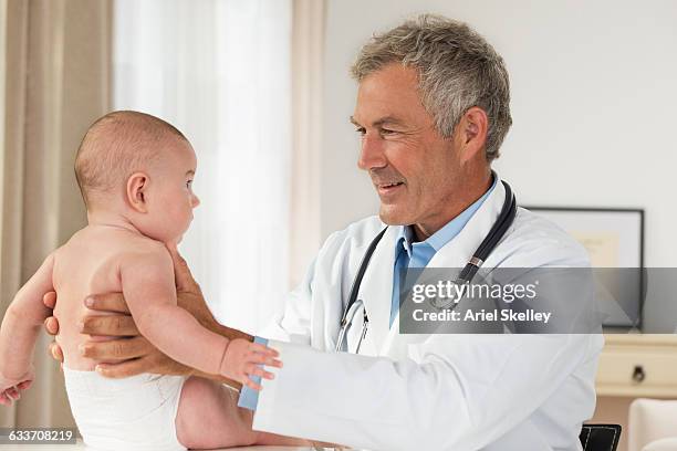 caucasian pediatrician examining baby boy - doctoring stock pictures, royalty-free photos & images