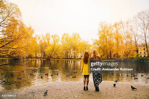 caucasian women admiring pond in park - woman full body behind stock pictures, royalty-free photos & images