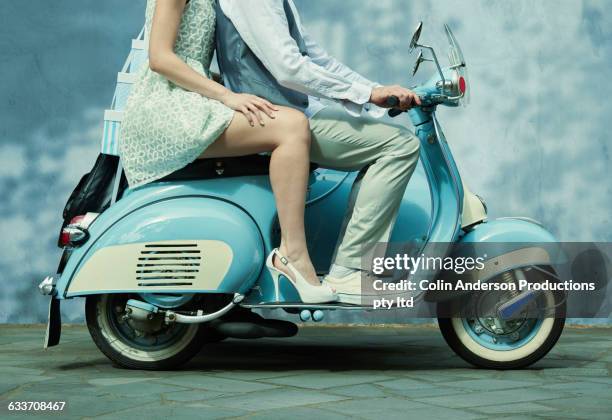 couple riding vintage scooter - bridal shop stockfoto's en -beelden