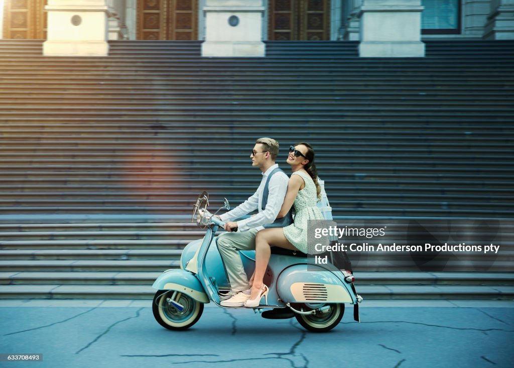 Couple driving vintage scooter