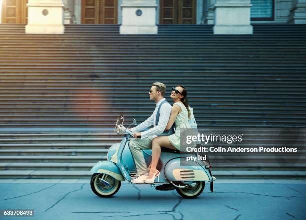 couple driving vintage scooter - interracial wife fotos stockfoto's en -beelden