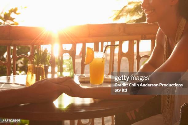 couple holding hands on patio - nusa dua stock pictures, royalty-free photos & images