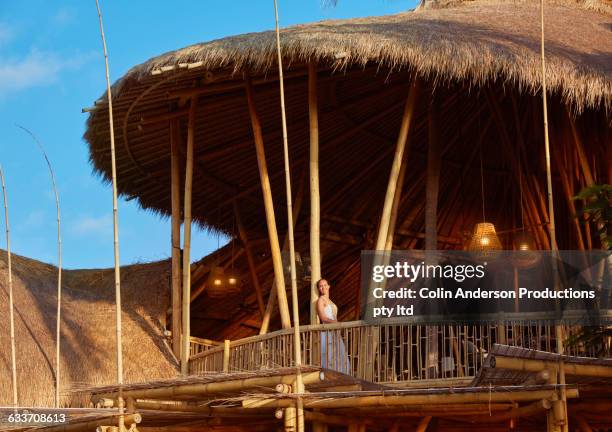 pacific islander woman standing on balcony - ヌサデュア ストックフォトと画像