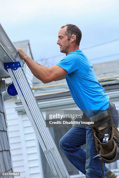 deaf caucasian roofer climbing ladder - taub stock-fotos und bilder