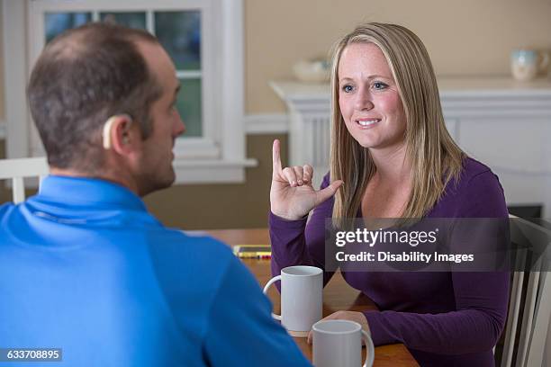 deaf caucasian couple signing at dinner table - american sign language stock pictures, royalty-free photos & images