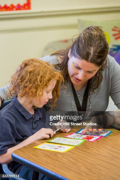 teacher helping student with project in classroom - flash card stock pictures, royalty-free photos & images
