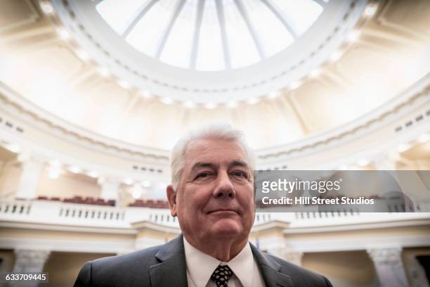 caucasian politician smiling in capitol building - politician portrait stock pictures, royalty-free photos & images