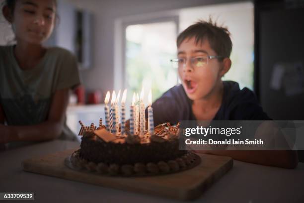 mixed race boy blowing birthday candles - palmerston north nz bildbanksfoton och bilder