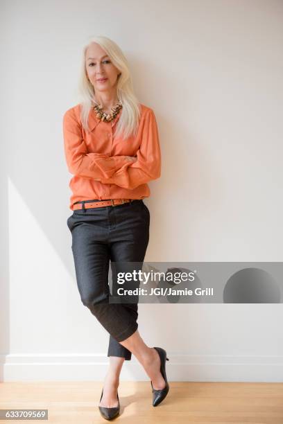 caucasian businesswoman standing with arms crossed - woman trousers stock pictures, royalty-free photos & images