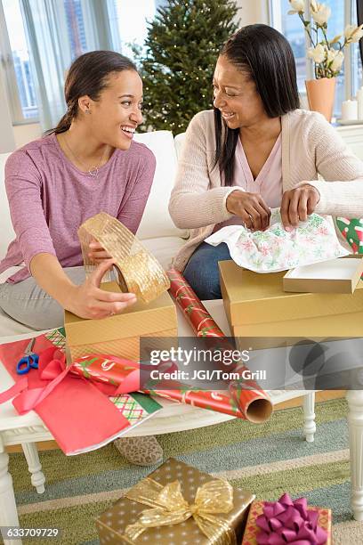 mother and daughter wrapping christmas gifts - black tape project stock pictures, royalty-free photos & images