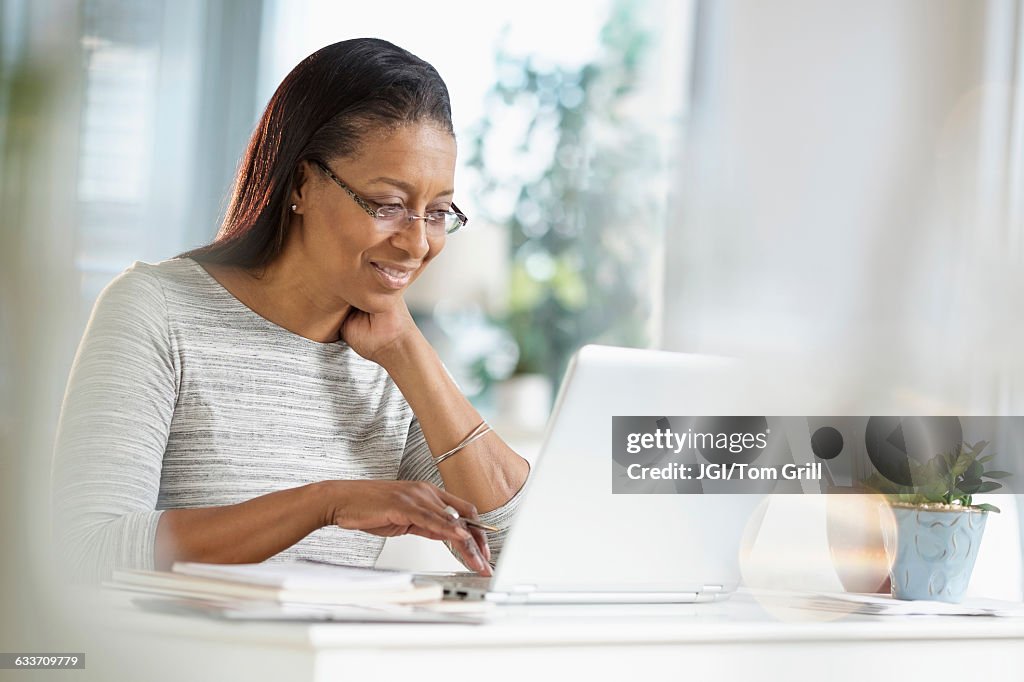 Mixed race woman using laptop