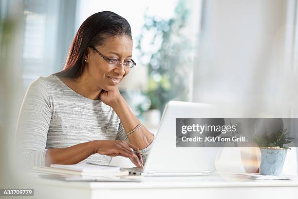 mixed race woman using laptop - searching computer stock pictures, royalty-free photos & images