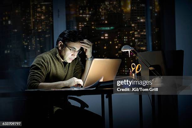 mixed race businessman working late in office - workload stock-fotos und bilder