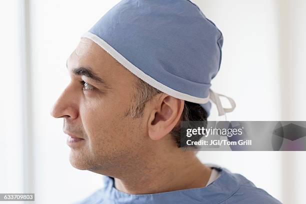 mixed race surgeon wearing scrubs - chirurgenkappe stock-fotos und bilder