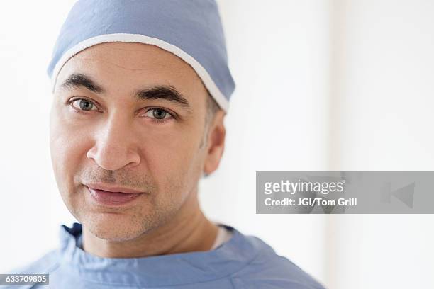 mixed race surgeon wearing scrubs - chirurgenkappe stock-fotos und bilder