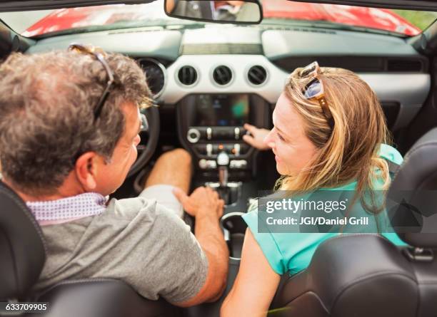 caucasian couple driving convertible - auto radio stock pictures, royalty-free photos & images