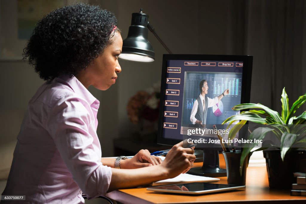 Mixed race businesswoman taking online class on computer