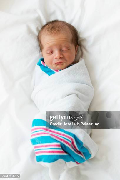 close up of sleeping mixed race newborn baby boy - babydeken stockfoto's en -beelden