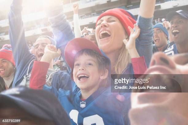 sports fans cheering in stadium - stadium crowd stock-fotos und bilder