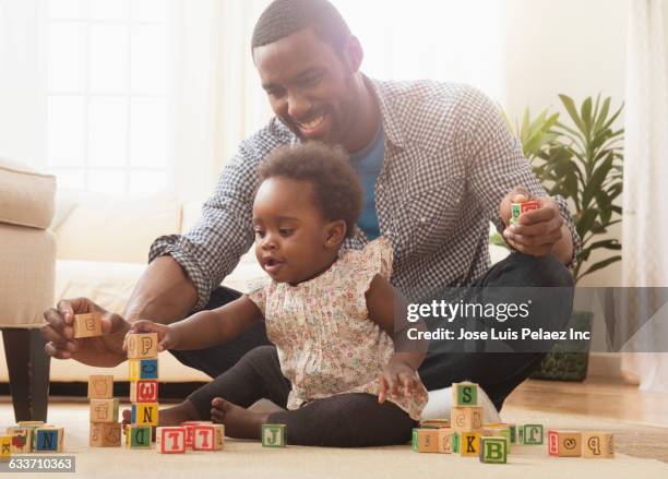 father and baby daughter playing with wooden blocks - één ouder stockfoto's en -beelden