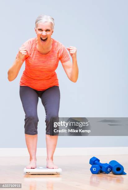 caucasian woman cheering on scale - happiness scale stock pictures, royalty-free photos & images