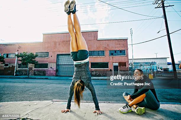 athlete doing handstand on sidewalk - hacer el pino fotografías e imágenes de stock