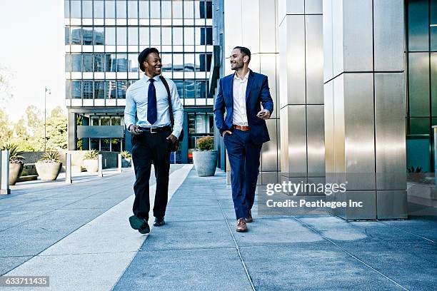 businessmen talking outside office building - building partnership stock pictures, royalty-free photos & images