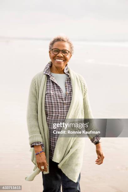 older african american woman walking on beach - water glasses ストックフォトと画像