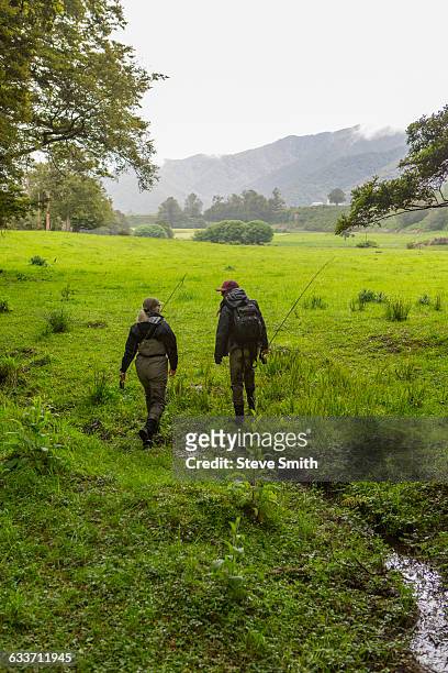 caucasian mother and daughter walking in remote field - fishing for leave stock-fotos und bilder