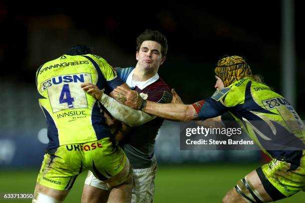 Tim Swiel of Harlequins is tackled by Bryn Evans and Magnus Lund of Sale Sharks during the Anglo-Welsh Cup match between Harlequins and Sale Sharks...