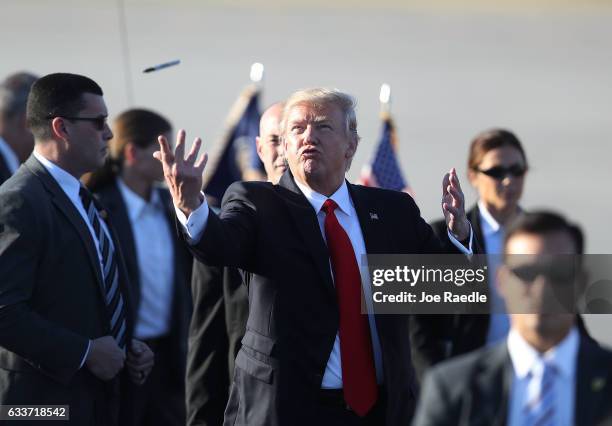 President Donald Trump tosses a sharpie pen that he was using for autographs back to the group that greeted him after arriving on Air Force One at...