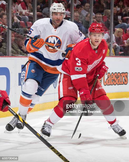 Nick Jensen of the Detroit Red Wings battles for position with Johnny Boychuk of the New York Islanders during an NHL game at Joe Louis Arena on...