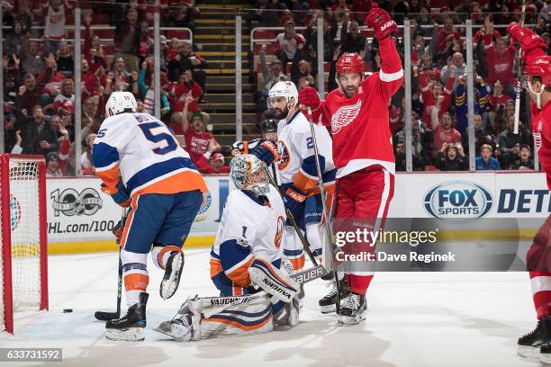 Luke Glendening of the Detroit Red Wings scores a first period goal as teammate Riley Sheahan celebrates in front of goaltender Thomas Greiss, Johnny...