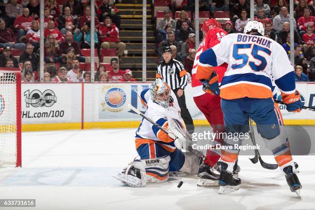 Luke Glendening of the Detroit Red Wings scores a first period goal as teammate Riley Sheahan screens the view of goaltender Thomas Greiss of the New...