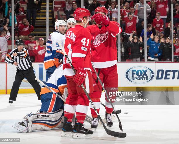 Luke Glendening of the Detroit Red Wings celebrates a first period goal with teammate Riley Sheahan in front of goaltender Thomas Greiss, Johnny...