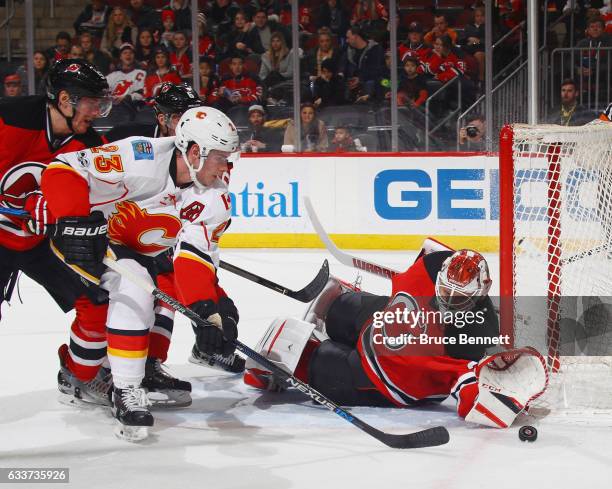 Cory Schneider of the New Jersey Devils makes the first period save on Sean Monahan of the Calgary Flames at the Prudential Center on February 3,...