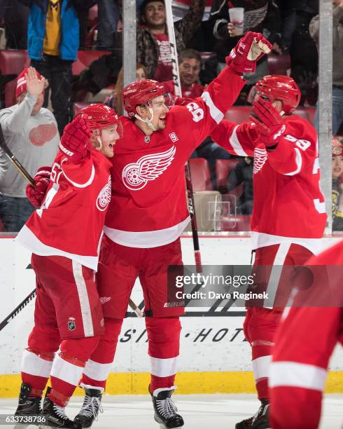 Danny DeKeyser of the Detroit Red Wings celebrates his game winning goal with teammates Gustav Nyquist and Anthony Mantha during an NHL game against...