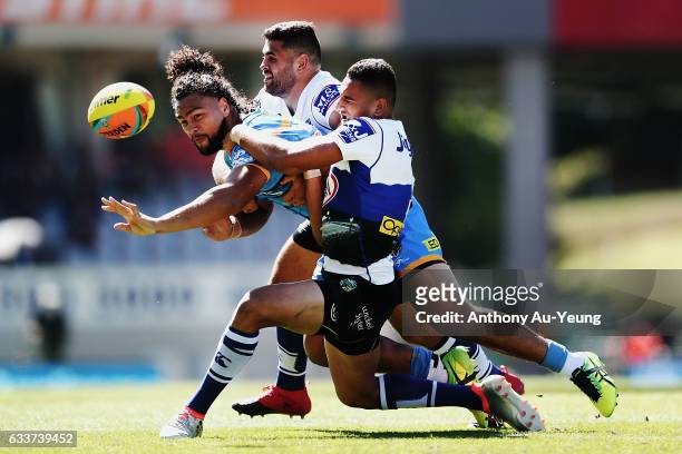 Leivaha Pulu of the Titans offloads the ball in a tackle during the 2017 Auckland Nines match between the Titans and the Bulldogs at Eden Park on...