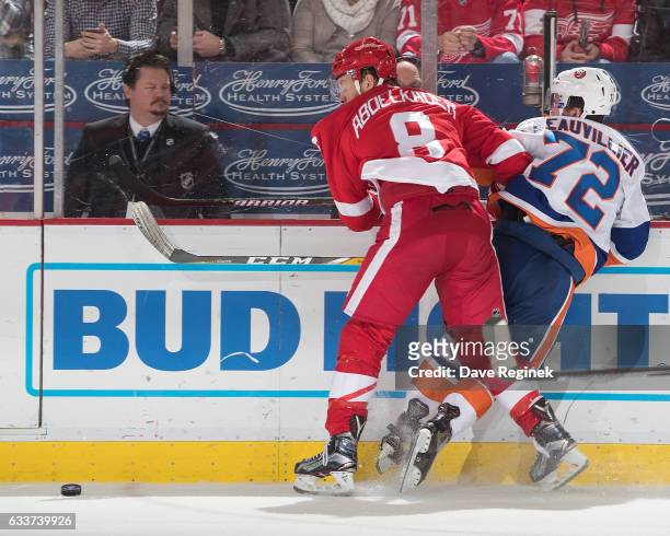 Justin Abdelkader of the Detroit Red Wings battles for the puck along the boards with Anthony Beauvillier of the New York Islanders during an NHL...