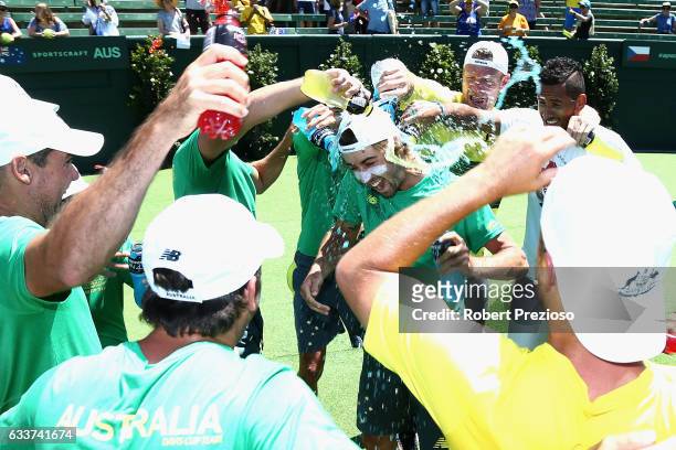 Jordan Thompson of Australia has drinks poured on him by team-mates after winning the tie against Czech Republic during the first round World Group...