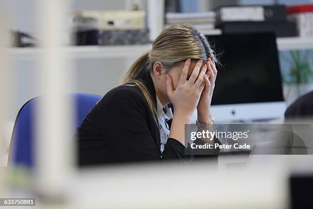 woman with head in hands sat at desk - girl in office stock pictures, royalty-free photos & images