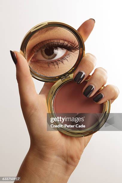 hand holding make up mirror with reflection of eye - esmalte de uñas negro fotografías e imágenes de stock