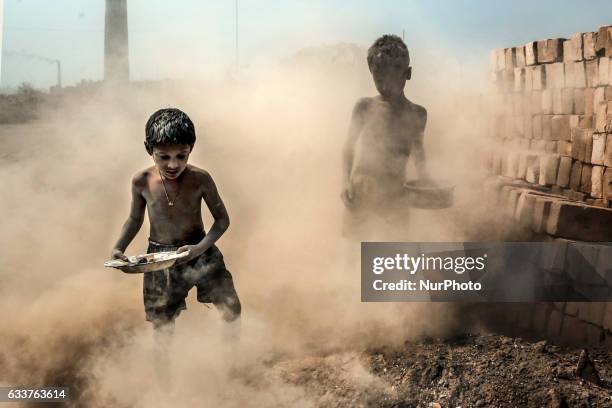 Two kids search coal in the brick dust in a brickfield, Narayanganj, Bangladesh, on February 4, 2017.