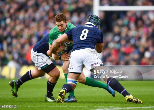 Edinburgh , United Kingdom - 4 February 2017; Paddy Jackson of Ireland is tackled by Zander Fagerson, left, and Josh Strauss of Scotland during the...