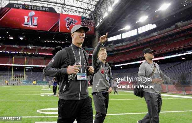 Matt Ryan of the Atlanta Falcons, Matt Schaub, and Matt Simms walk on the turf during the Super Bowl LI team walk through at NRG Stadium on February...