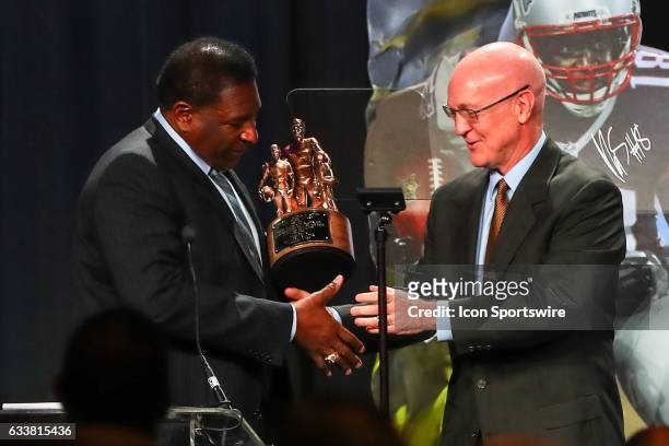Hall of Famer Jackie Slater receives the Bart Starr Award from Bart Starr Jr for his son New England Patriots wide receiver Matthew Slater during the...