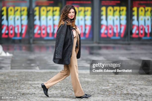 Insaf Bennis, fashion blogger from Sparkles in Paris, wears a Levi's gray wool coat, Apostrophe camel suit and pants, Mango black shoes, a black top,...