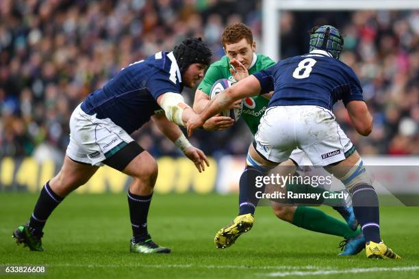 Edinburgh , United Kingdom - 4 February 2017; Paddy Jackson of Ireland is tackled by Zander Fagerson, left, and Josh Strauss of Scotland during the...