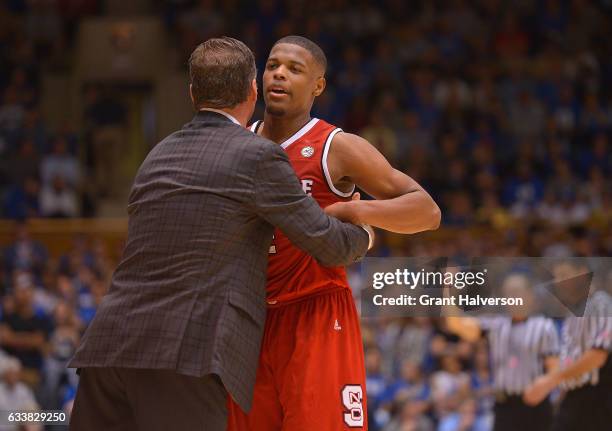 Head coach Mark Gottfried of the North Carolina State Wolfpack hugs Dennis Smith Jr. #4 of the North Carolina State Wolfpack during their win against...